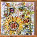 A square framed art print featuring a whimsical, colorful illustration of sunflowers and birds on a patterned background, set in a natural wood frame.